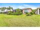 Lush backyard featuring well-maintained lawn, mature landscaping, and screened patio at 4949 Sandy Brook Cir, Wimauma, FL 33598