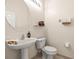 Half bath with pedestal sink, round mirror, and tile floors at 4949 Sandy Brook Cir, Wimauma, FL 33598