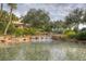 Scenic pond with waterfalls and lush landscaping within the Valencia Lakes community at 4949 Sandy Brook Cir, Wimauma, FL 33598