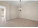 Chandelier-lit, tiled room with neutral walls, baseboards, and an open doorway at 4949 Sandy Brook Cir, Wimauma, FL 33598