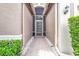View of front entryway, with a decorative glass door and manicured landscaping at 4949 Sandy Brook Cir, Wimauma, FL 33598