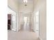 Bright hallway featuring neutral walls, tile flooring, and multiple doorways at 4949 Sandy Brook Cir, Wimauma, FL 33598