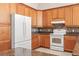 Spacious kitchen features wood cabinets, white appliances, and tiled backsplash at 4949 Sandy Brook Cir, Wimauma, FL 33598