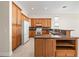 Open-concept kitchen boasts wooden cabinetry, granite countertops, and modern appliances at 4949 Sandy Brook Cir, Wimauma, FL 33598