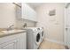 Laundry area with modern appliances, sink, and ample storage space at 4949 Sandy Brook Cir, Wimauma, FL 33598