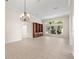 Large empty living room with tiled floor, a chandelier, built-in shelves, and large window at 4949 Sandy Brook Cir, Wimauma, FL 33598