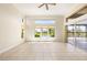 Bright and spacious living room with tile floors, high ceilings and sliders to a lanai overlooking a lake at 4949 Sandy Brook Cir, Wimauma, FL 33598