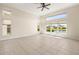 Spacious living room with tile floors, high ceilings and many windows overlooking a lake at 4949 Sandy Brook Cir, Wimauma, FL 33598