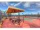 Pickle ball courts with shade and picnic tables under a large gazebo with lighting surrounded by fencing and green spaces at 4949 Sandy Brook Cir, Wimauma, FL 33598