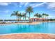 Community swimming pool and lounge chairs located near beautiful waterfront with palm trees and gazebos for shade at 4949 Sandy Brook Cir, Wimauma, FL 33598