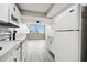 White kitchen cabinets, stainless steel appliances and gray flooring at 5095 Bay Ne St # 306, St Petersburg, FL 33703