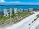 Aerial view of pristine beach and luxurious condo buildings at 1200 Gulf Blvd # 105, Clearwater Beach, FL 33767