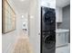 Bright laundry room with stackable washer and dryer, white cabinets, and a utility sink at 1200 Gulf Blvd # 105, Clearwater Beach, FL 33767