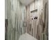 Large walk-in shower with marble tile and built-in shelving at 1200 Gulf Blvd # 105, Clearwater Beach, FL 33767