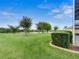 Lush backyard with manicured lawn, trees and landscaping at 13217 Thoroughbred Dr, Dade City, FL 33525
