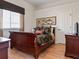 Cozy bedroom featuring a wood sleigh bed and window at 13217 Thoroughbred Dr, Dade City, FL 33525