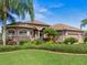 Beautiful one-story home with a well-manicured lawn and palm trees at 13217 Thoroughbred Dr, Dade City, FL 33525