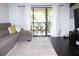 Living room with gray sectional sofa and access to balcony at 1398 Shady Pine Way # H3, Tarpon Springs, FL 34688