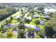 Aerial view of a community with houses, ponds, and lush greenery at 1398 Shady Pine Way # H3, Tarpon Springs, FL 34688