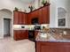 Kitchen features dark wood cabinets, granite countertops, and black appliances at 13217 Thoroughbred Dr, Dade City, FL 33525