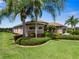 Beautiful home exterior with palm trees and well-manicured lawn at 13217 Thoroughbred Dr, Dade City, FL 33525