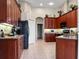 Kitchen features dark wood cabinets, granite counters, and stainless steel appliances at 13217 Thoroughbred Dr, Dade City, FL 33525