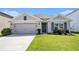 Two-car garage, neutral color scheme, and nicely landscaped lawn at 7774 Sail Clover Ln, Zephyrhills, FL 33540