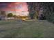 Backyard with fire pit and seating area at sunset at 1478 Alternate Keene Rd, Largo, FL 33771