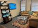 Bright living room featuring comfortable seating, a large TV, and coastal-themed decor at 1478 Alternate Keene Rd, Largo, FL 33771