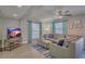 Living room features sectional sofa, wood look floors and a large TV at 1478 Alternate Keene Rd, Largo, FL 33771