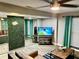 Bright living room with a TV, comfortable seating, and a leafy accent wall at 1478 Alternate Keene Rd, Largo, FL 33771