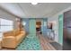 Living room with light tan couch, teal rug, and barn door at 1478 Alternate Keene Rd, Largo, FL 33771