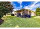 Home's backyard with screened patio, grill, and lush lawn at 15907 Cobble Mill Dr, Wimauma, FL 33598