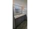 Bathroom vanity with granite countertop, modern fixtures, and grey cabinets at 1370 Heather Ridge Blvd # 107, Dunedin, FL 34698