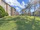 Exterior view of building surrounded by green grass and mature trees at 1370 Heather Ridge Blvd # 107, Dunedin, FL 34698
