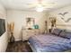 Cozy bedroom featuring wood floors, ceiling fan, beach artwork, and queen size bed at 15207 Taralane Ave, Brooksville, FL 34604