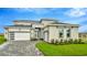 Elegant two-story home boasting a manicured lawn, paver driveway, and modern architectural details at 32252 Wetland Bird Vw, San Antonio, FL 33576