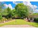 Serene backyard featuring manicured lawn, mature trees, and a fire pit for outdoor entertaining at 6419 Marbella Blvd, Apollo Beach, FL 33572