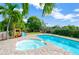 Beautiful backyard with a pool, hot tub, lush greenery, and a playground for outdoor enjoyment at 6419 Marbella Blvd, Apollo Beach, FL 33572