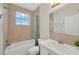 Bathroom featuring neutral tiling, a shower-tub combo, and a white vanity with ample counter space at 6419 Marbella Blvd, Apollo Beach, FL 33572