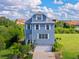 Charming three-story home features a paved driveway and a two-car garage in a serene residential setting at 6419 Marbella Blvd, Apollo Beach, FL 33572