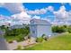 An aerial view of a beautiful two-story blue home with a driveway, lush yard, and a pool at 6419 Marbella Blvd, Apollo Beach, FL 33572