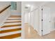 Hallway featuring hardwood stairs, neutral tile floor, and white doors and trim at 6419 Marbella Blvd, Apollo Beach, FL 33572
