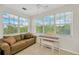 Inviting living room featuring a comfortable couch, piano, and large windows with views at 6419 Marbella Blvd, Apollo Beach, FL 33572