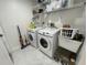 Bright laundry room complete with washer, dryer, and shelving at 1460 Overland Dr, Spring Hill, FL 34608