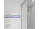 Bathroom featuring a tiled shower with a glass door, tiled walls, and a decorative towel rack at 500 Treasure Island Cswy # 406, Treasure Island, FL 33706