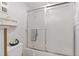 Bathroom featuring a frosted glass shower door, white tile walls, and a toilet at 500 Treasure Island Cswy # 406, Treasure Island, FL 33706