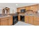 Traditional kitchen with wooden cabinets and black appliances at 500 Treasure Island Cswy # 406, Treasure Island, FL 33706