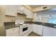 Updated kitchen with white cabinets, granite countertops, and a white stove at 11335 Grandville Dr, Temple Terrace, FL 33617