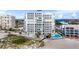 Aerial view showcasing condo building, pool, and beach proximity at 4950 Gulf Blvd # 104, St Pete Beach, FL 33706